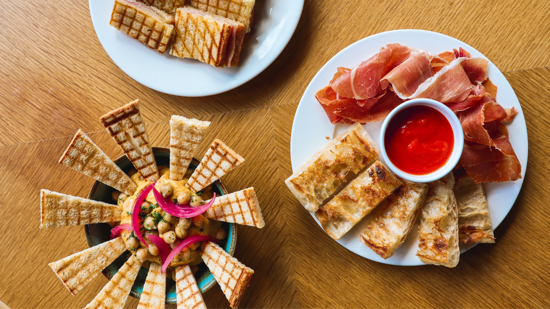Assiette de tapas avec jambon et pain grillé.
