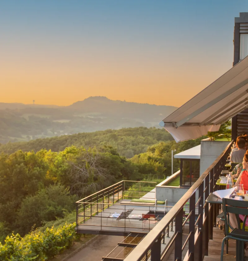 Restaurant avec vue sur la ville au coucher du soleil.