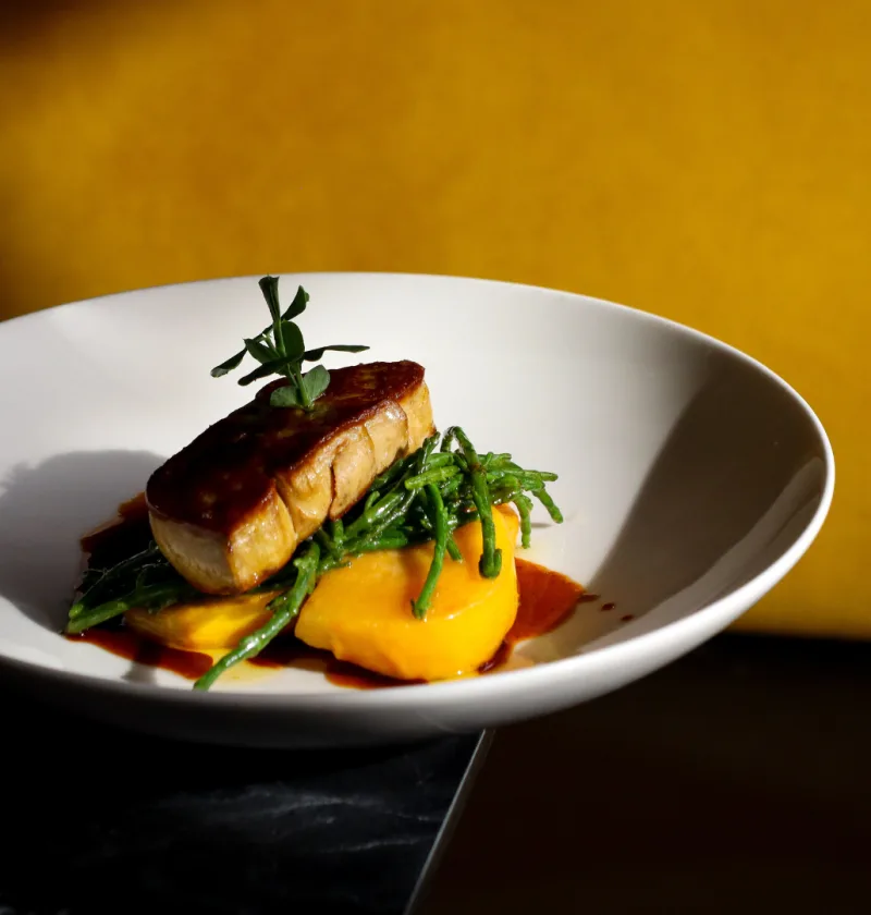 Plat de foie gras avec purée et légumes verts.