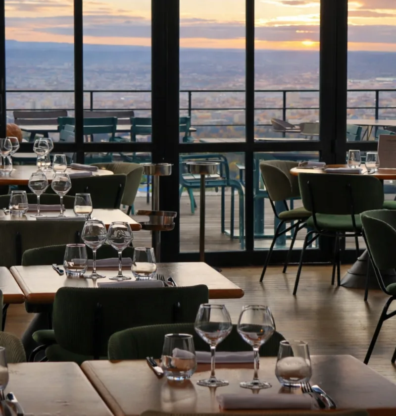 Restaurant avec vue sur la ville au coucher du soleil.