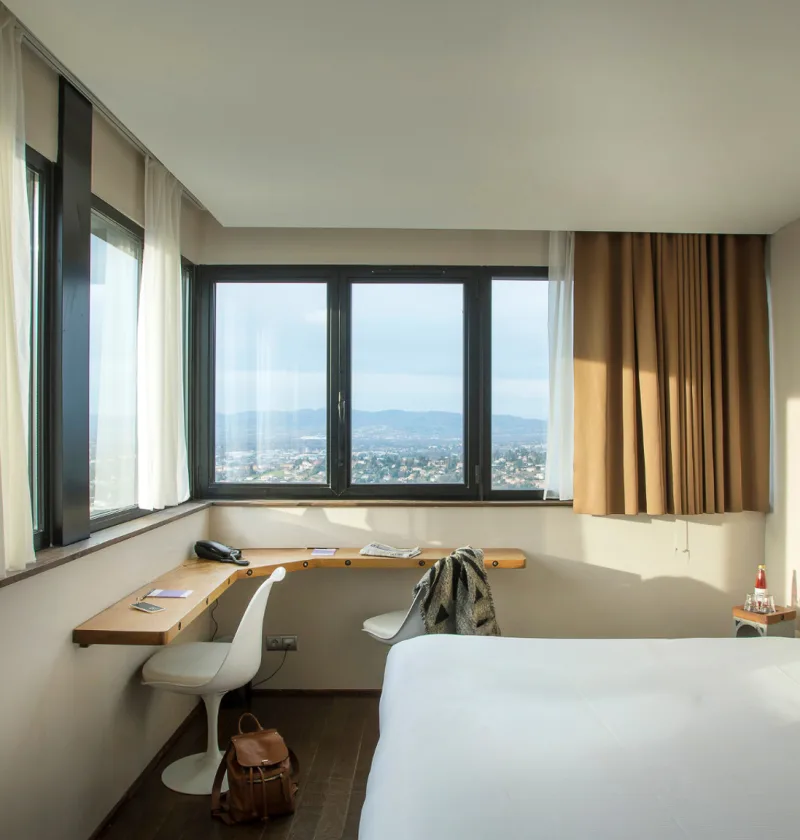 Chambre d'hôtel avec vue panoramique et bureau.